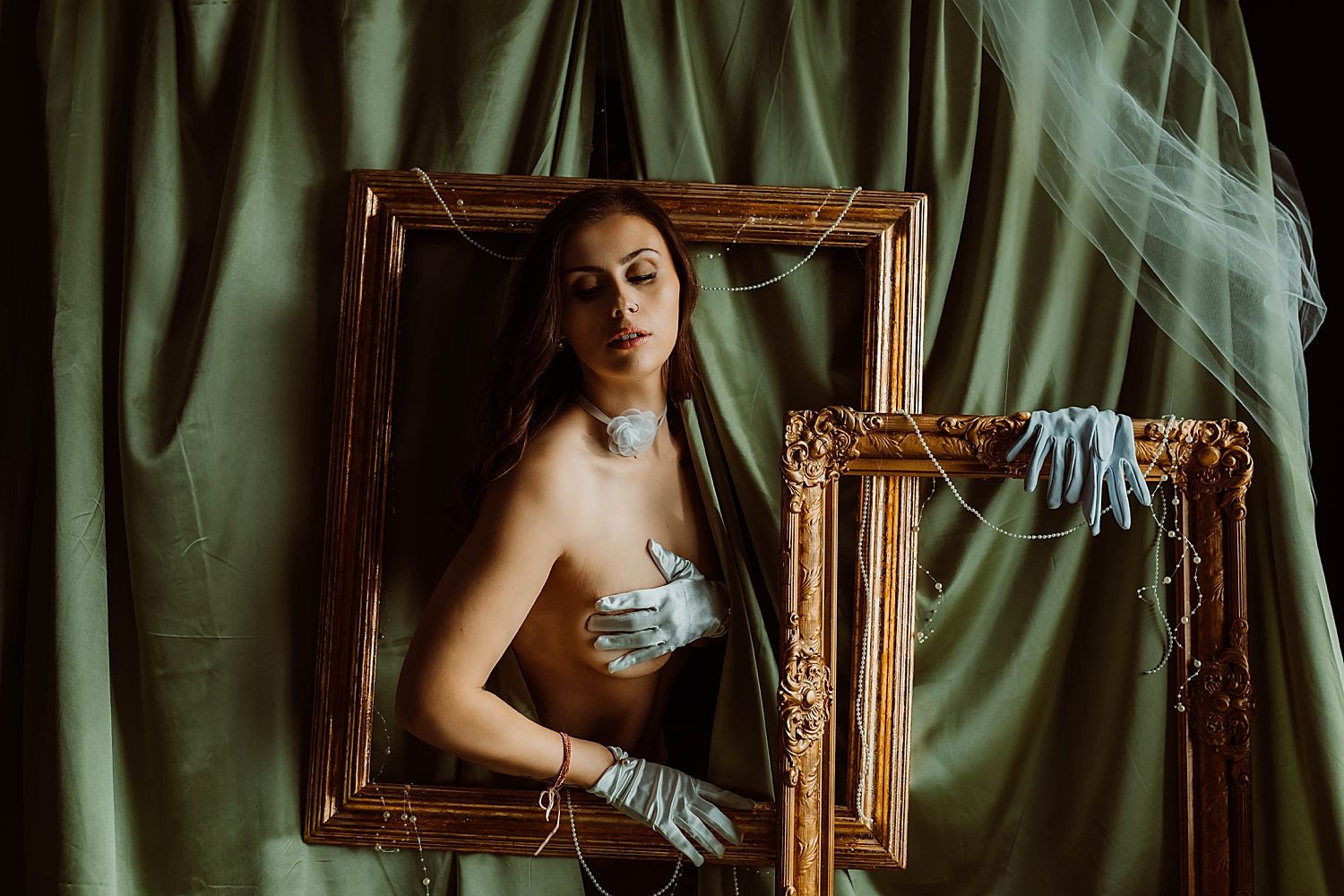 topless woman wearing blue glooves sits inside gold frame by Boudoir by KJ