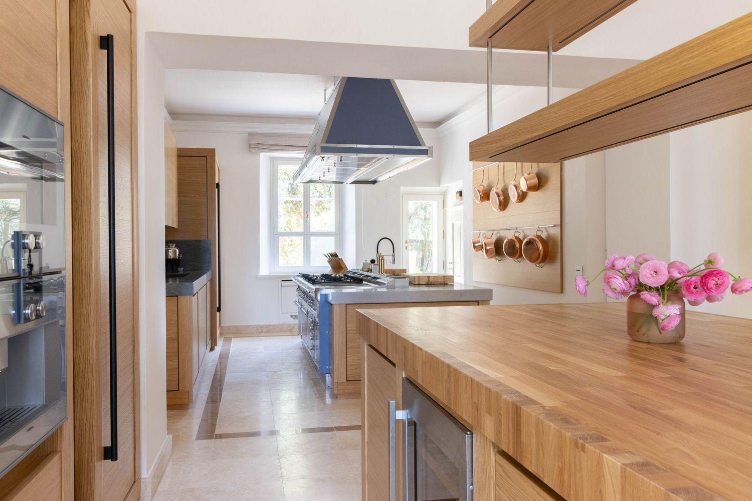 Tuscany villa photographer. Long hallway with warm wood cabinetry and modern lighting showcases sleek minimalist interior design.