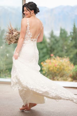 Elegant bridal portraits showing the back of a lace wedding gown as it swishes and twirls in natural light.
