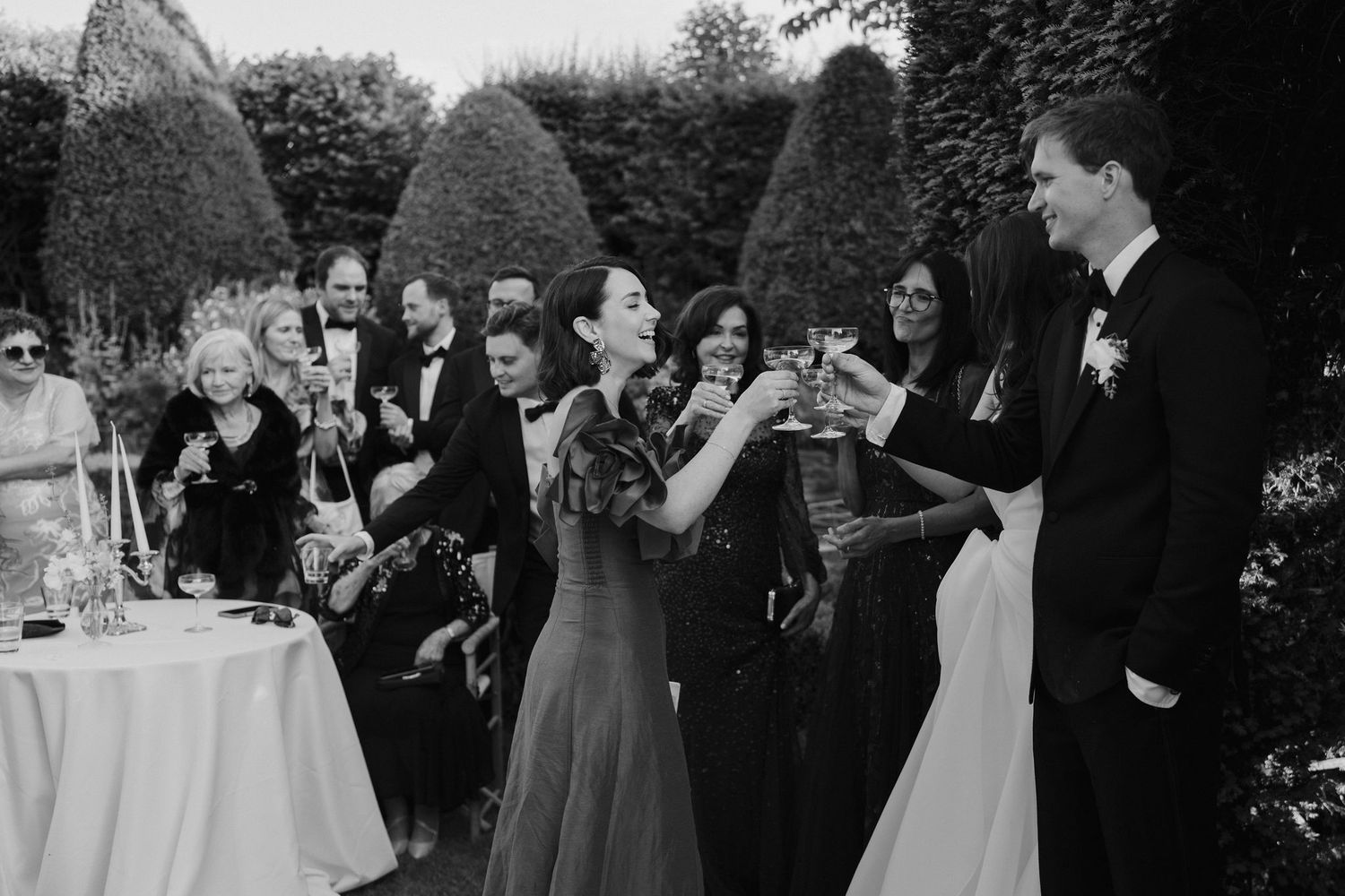 brides sister clinking glasses with groom after speeches on the lawn at dewsall court in hereforshire