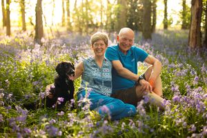 People and dogs relaxing in a wildflower meadow during golden hour.