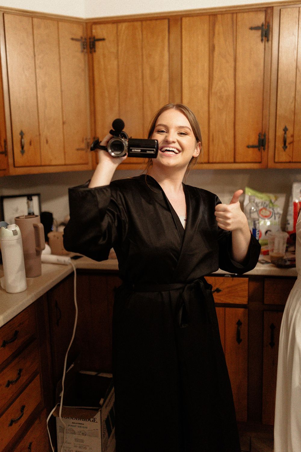 Wooden paneled kitchen interior with someone holding a hair dryer in a playful pose.