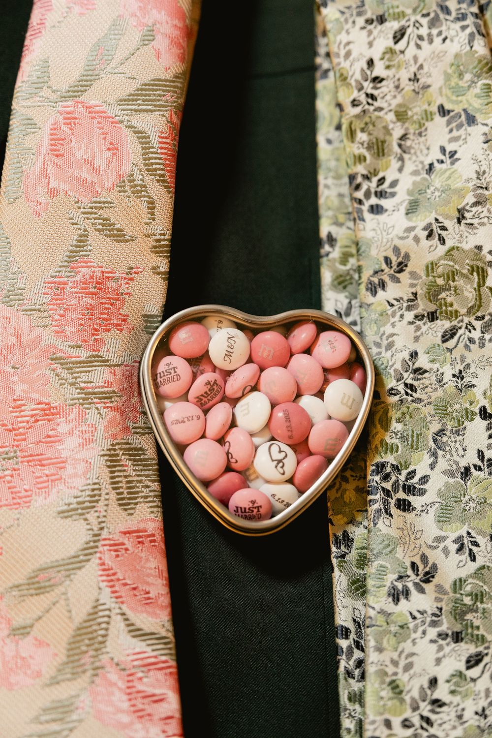 Heart-shaped jewelry displays with pink candies or beads arranged on a floral patterned fabric background.