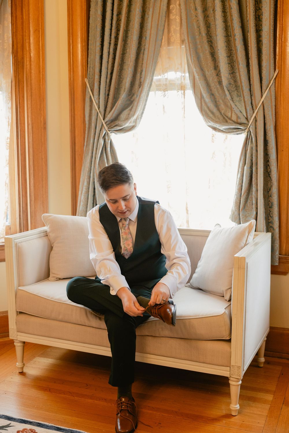 Series of photos showing someone sitting on a white couch in formal attire near a window with curtains.