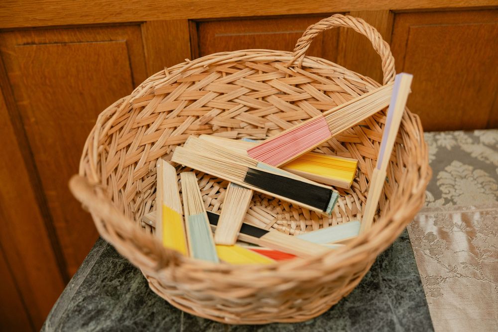 Woven basket filled with colorful notecards and papers on wooden surface.