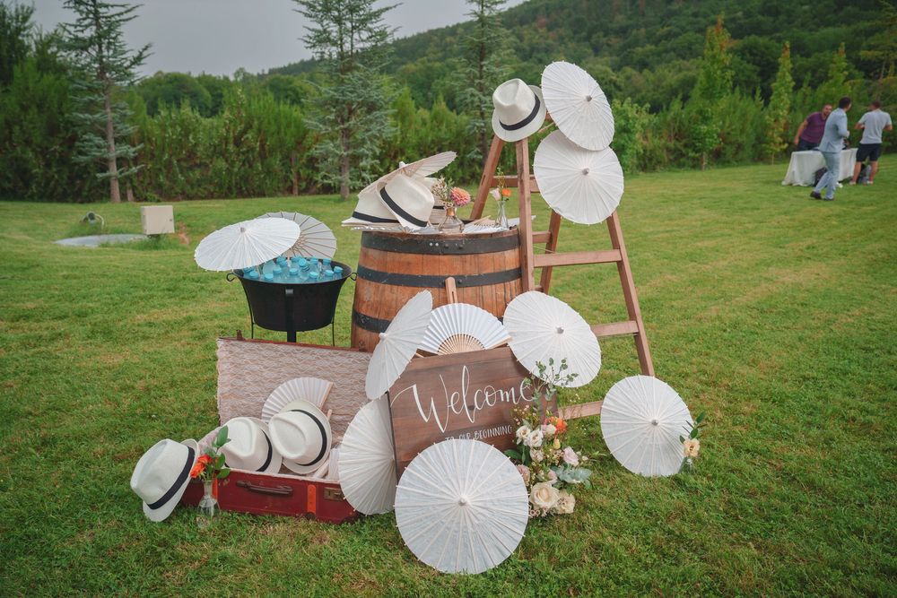 White parasols and wedding decor arranged beautifully on a lush green lawn with mountains in the background.