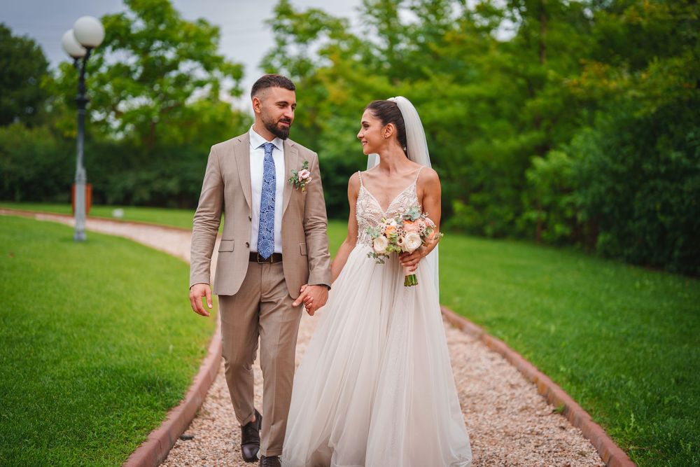 Couple walking along a winding garden path surrounded by green landscaping.
