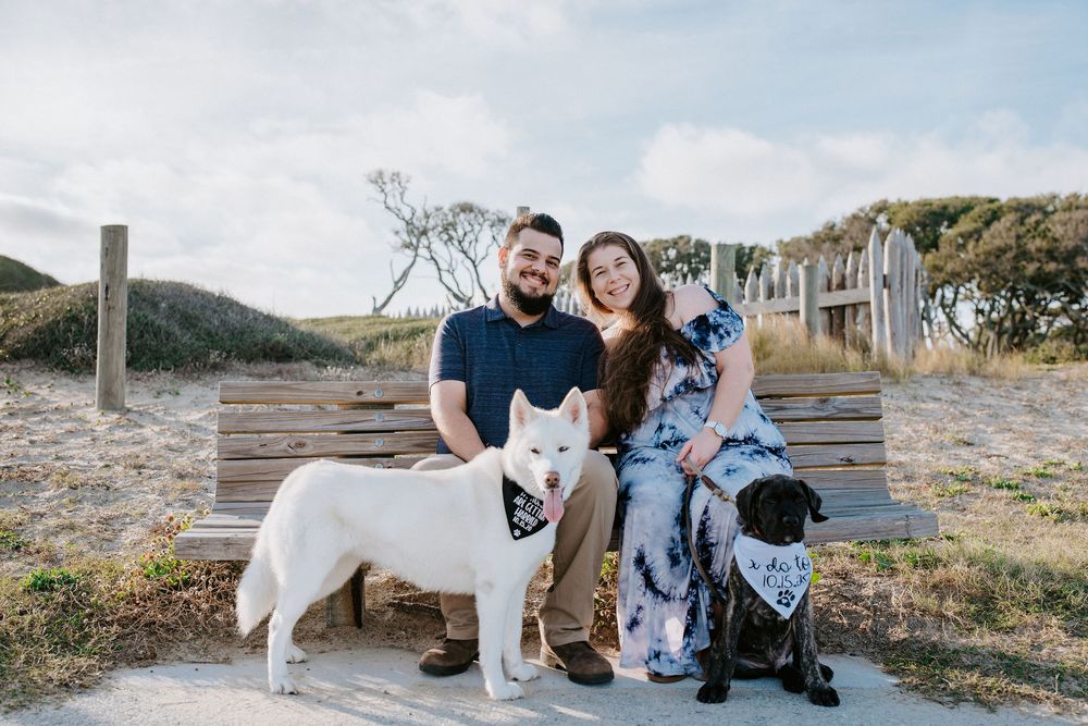 Family and their white dog pose together in a series of outdoor portraits at sunset in a rustic setting.