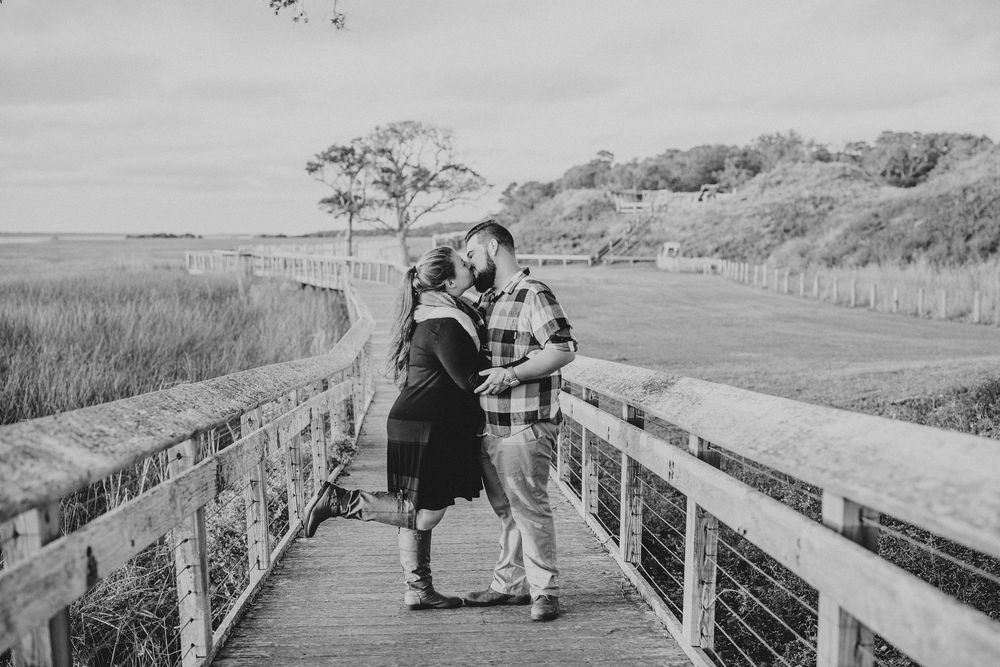 A series of black and white landscape photos showing a wooden boardwalk path through coastal dunes and marshland.