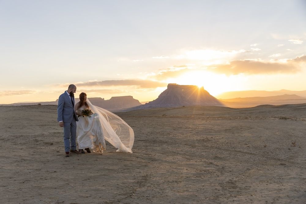 A series of photos showing a couple in wedding attire posing in a desert landscape at sunset.