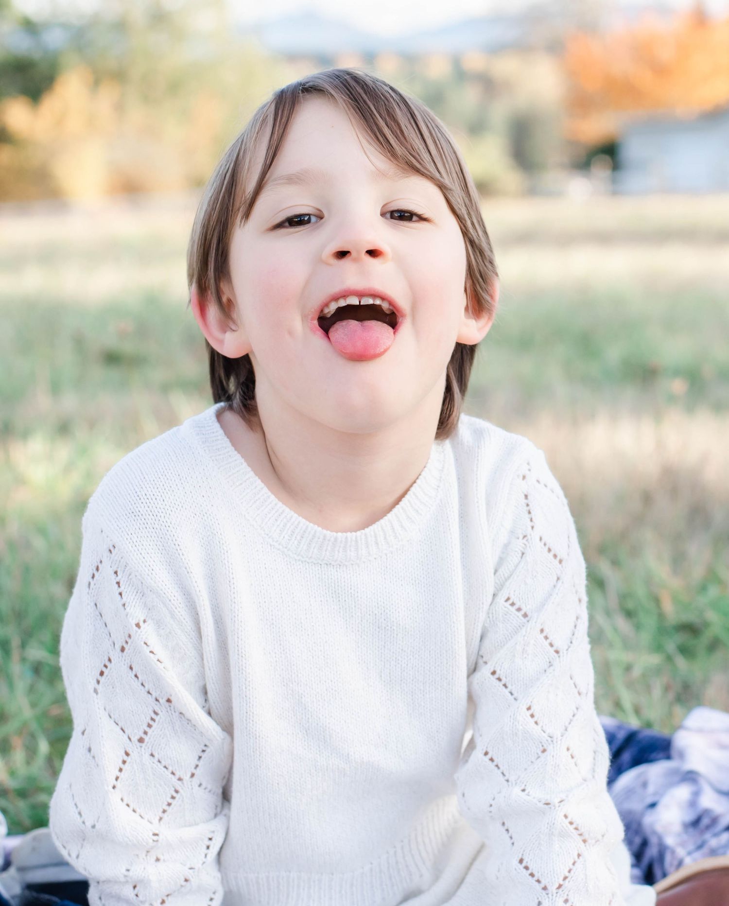 A series of candid photos showing playful expressions and joyful moments in a white sweater against an outdoor backdrop.