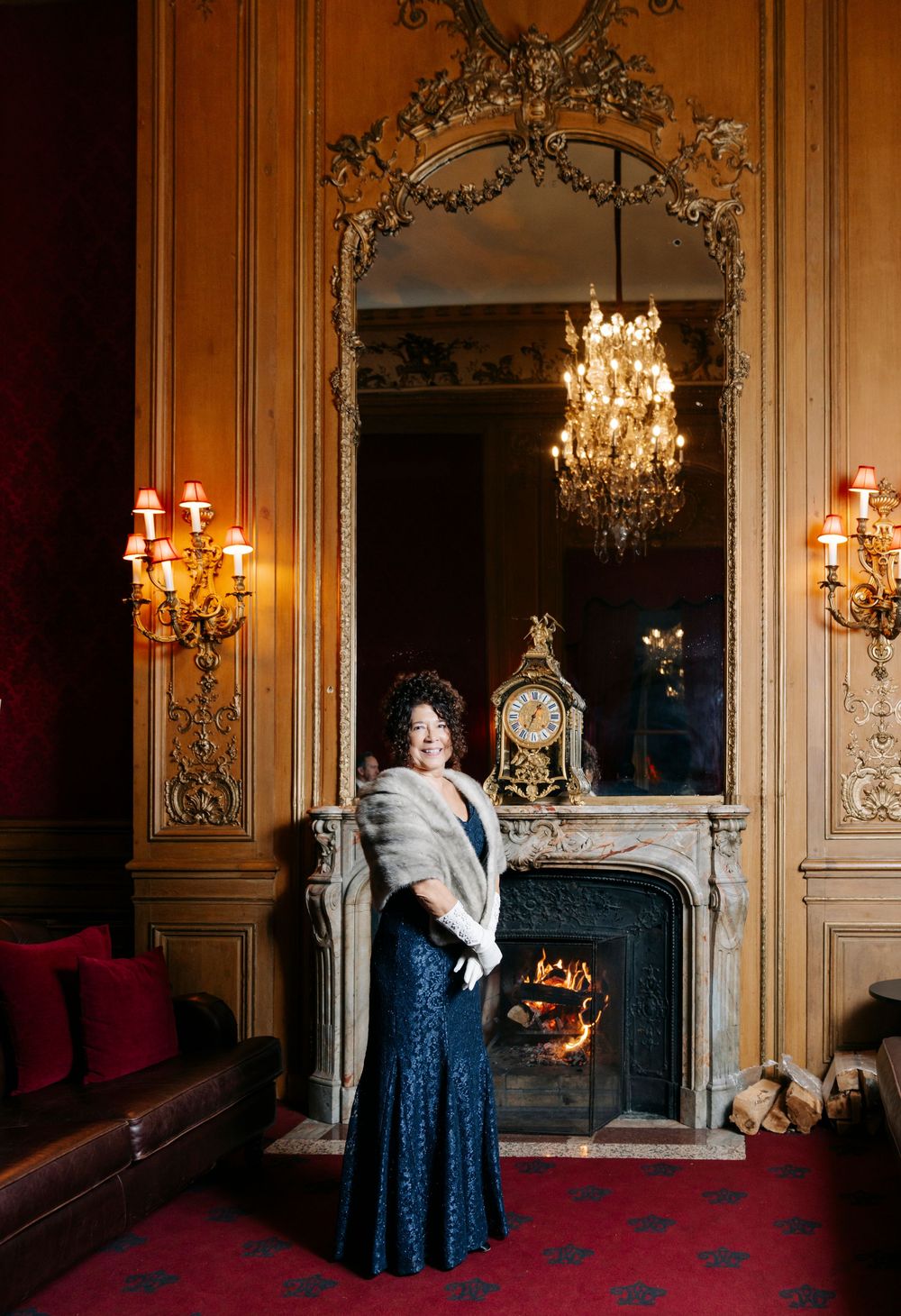 A sequence of photos showing someone in a dark blue gown posing in an ornate room with chandeliers and gilded walls.