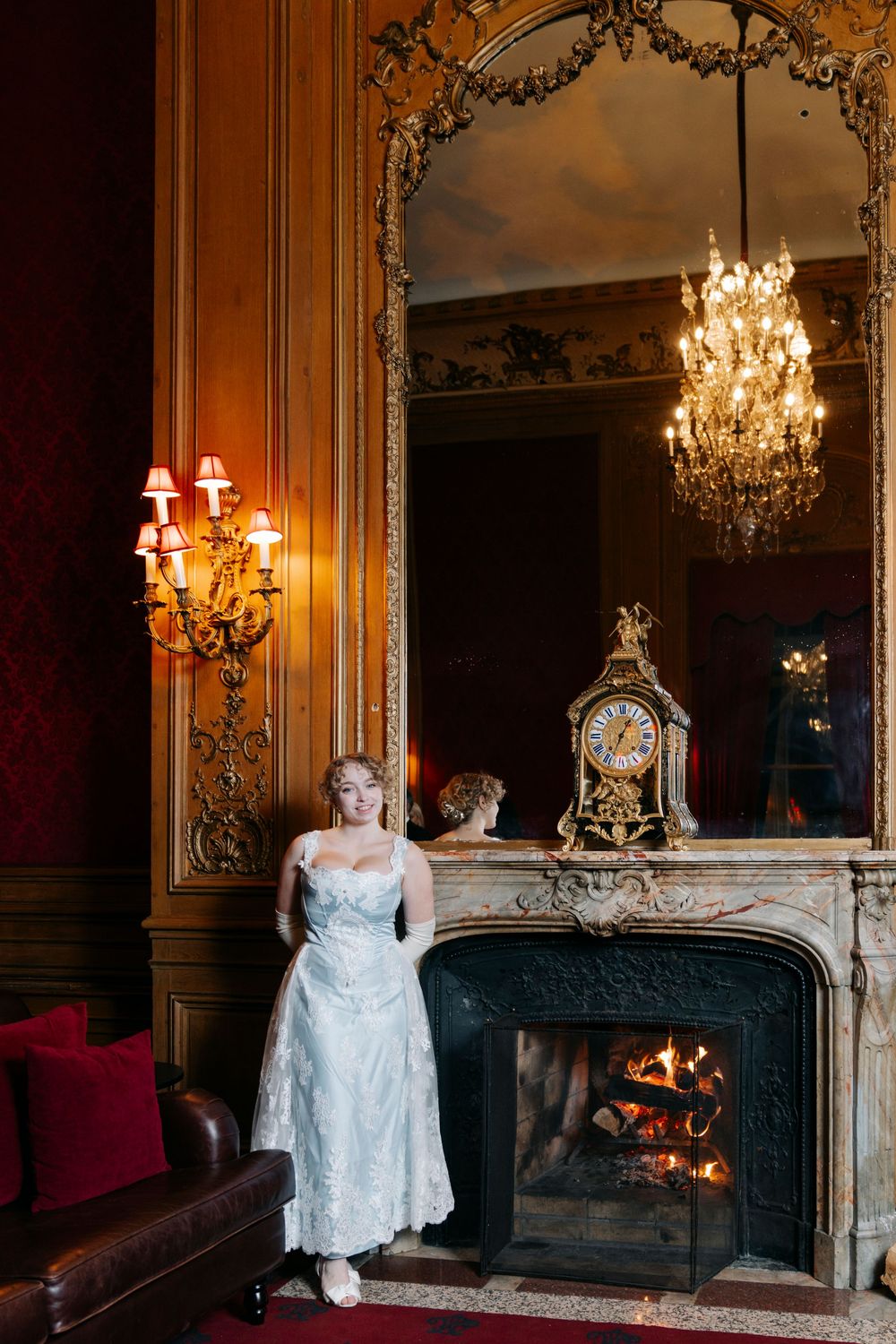 Elegant wedding photography series in a luxurious room with ornate fireplace, crystal chandeliers and warm lighting.