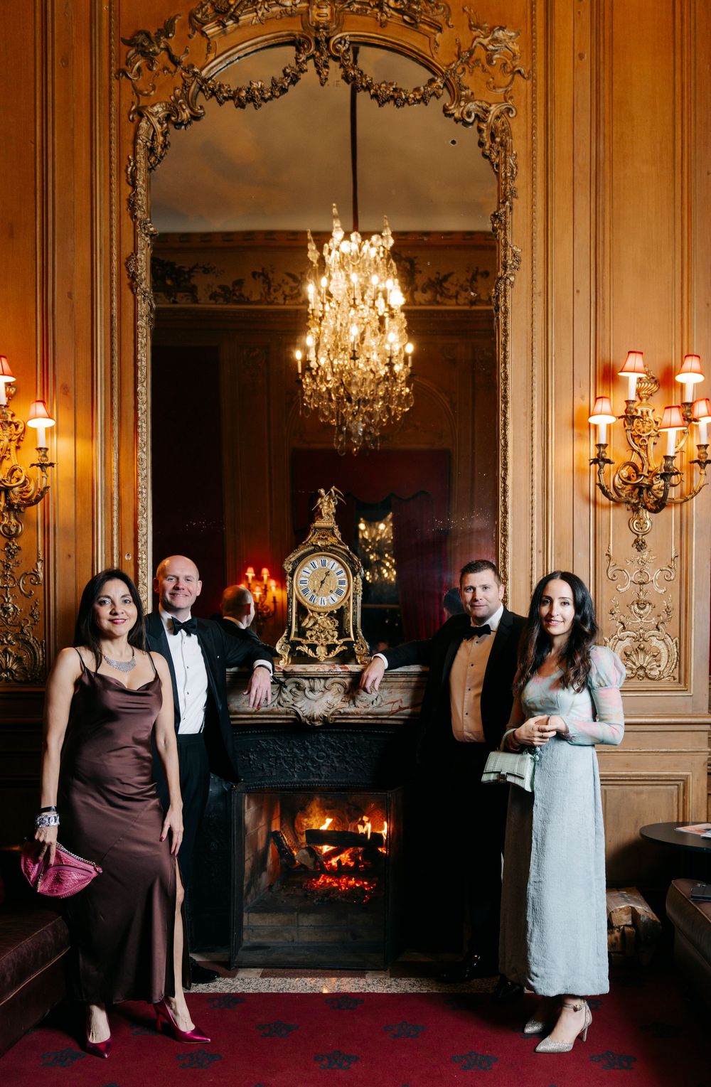 Elegant ballroom dance sequence with couples in formal attire against ornate walls with chandeliers and fireplace.