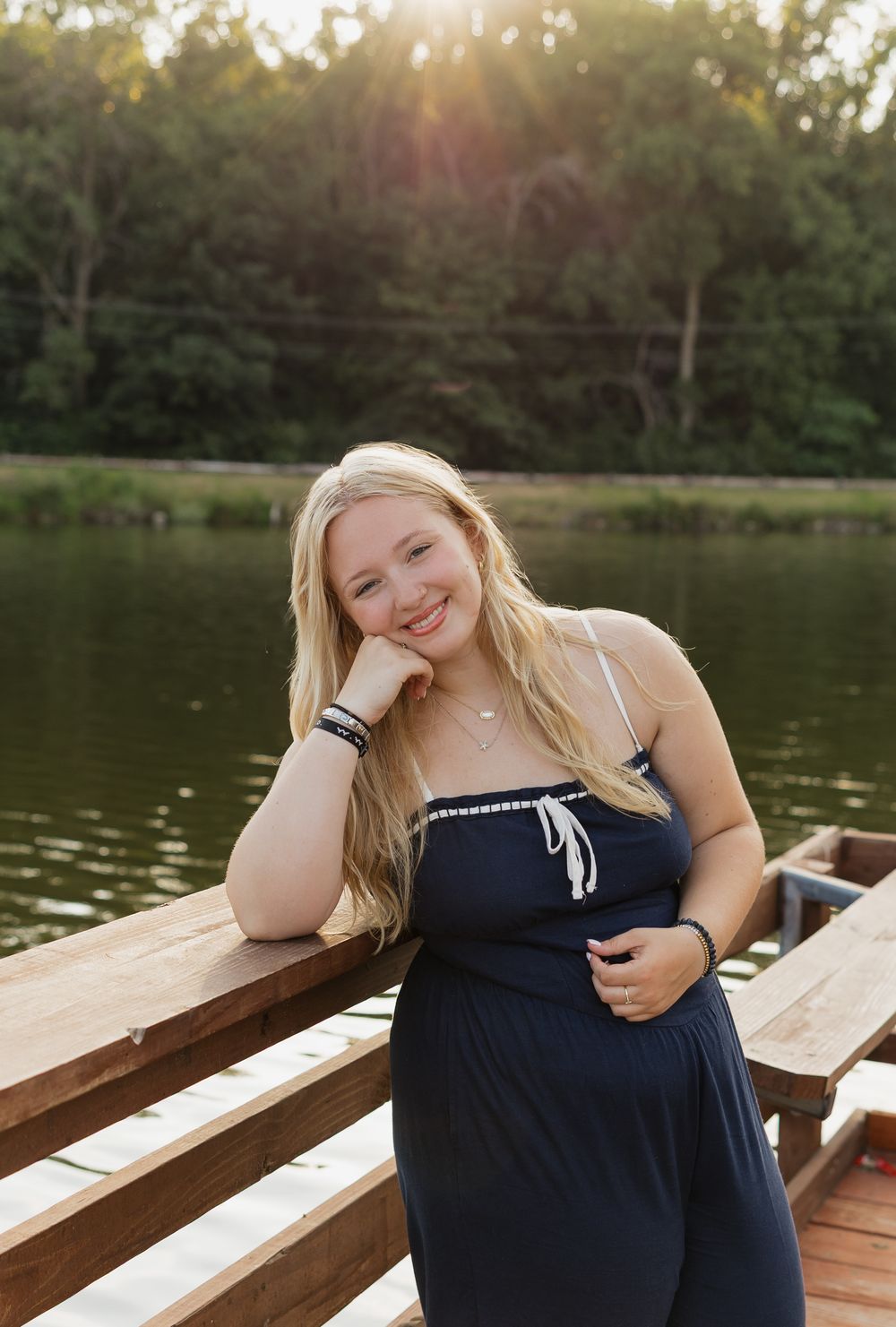 A sunset portrait on a wooden dock by a peaceful lake.