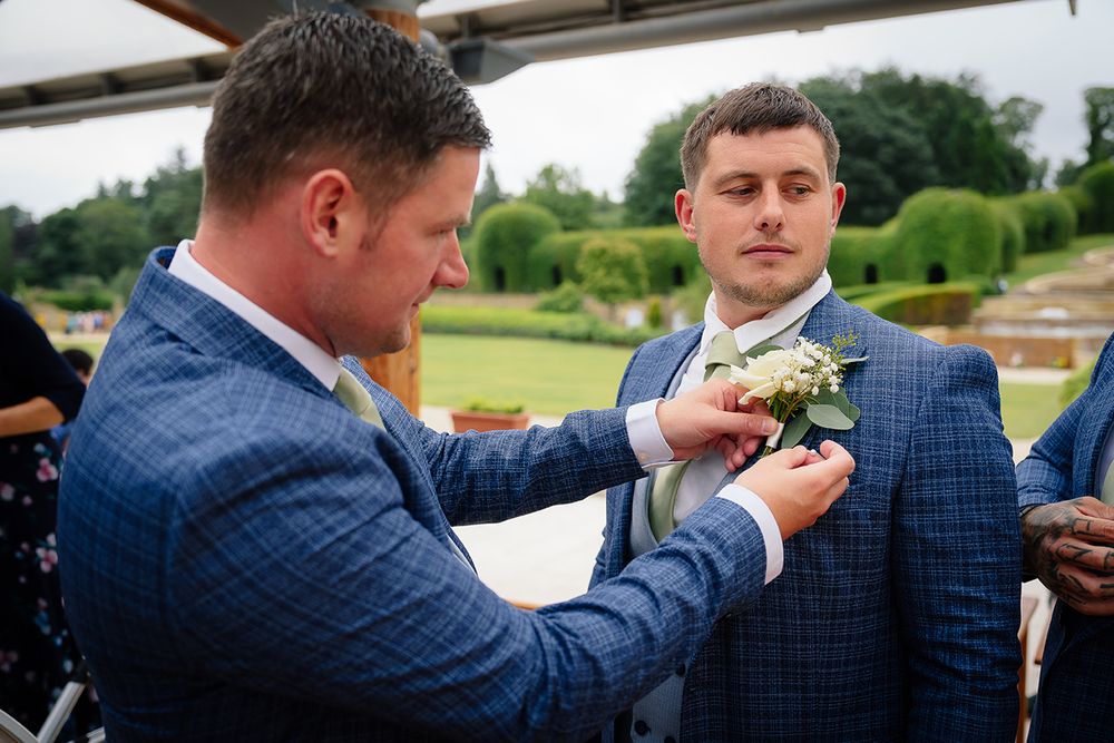 A group wearing navy blue suits shares appetizers and drinks at an outdoor event.