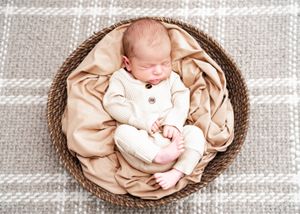 A series of sepia-toned newborn photography images showing a sleeping baby wrapped in soft fabric.