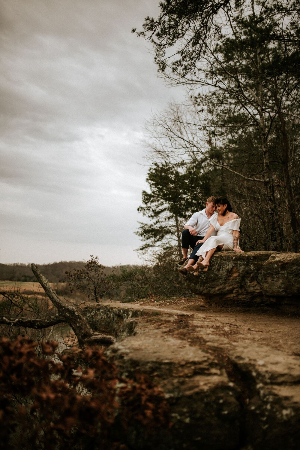 Bride and groom after their adventure elopement sitting together on a rock taking in the view from the adventure hike.