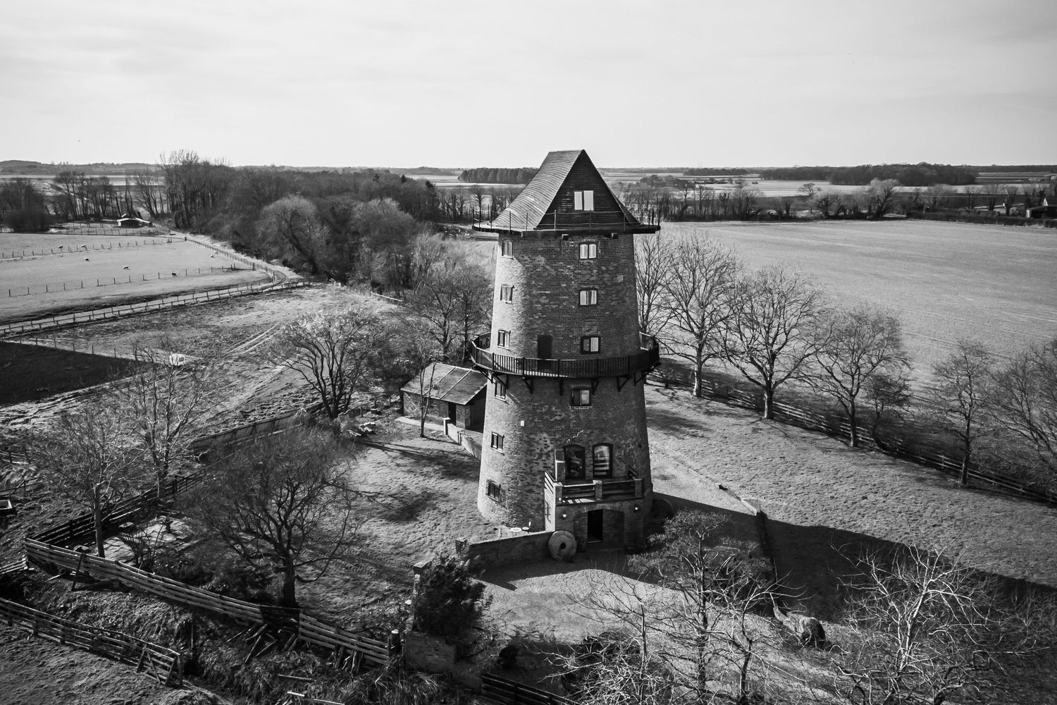 Aerial view of The Windmill in Burscough wedding venue surrounded by countryside, black and white drone photo
