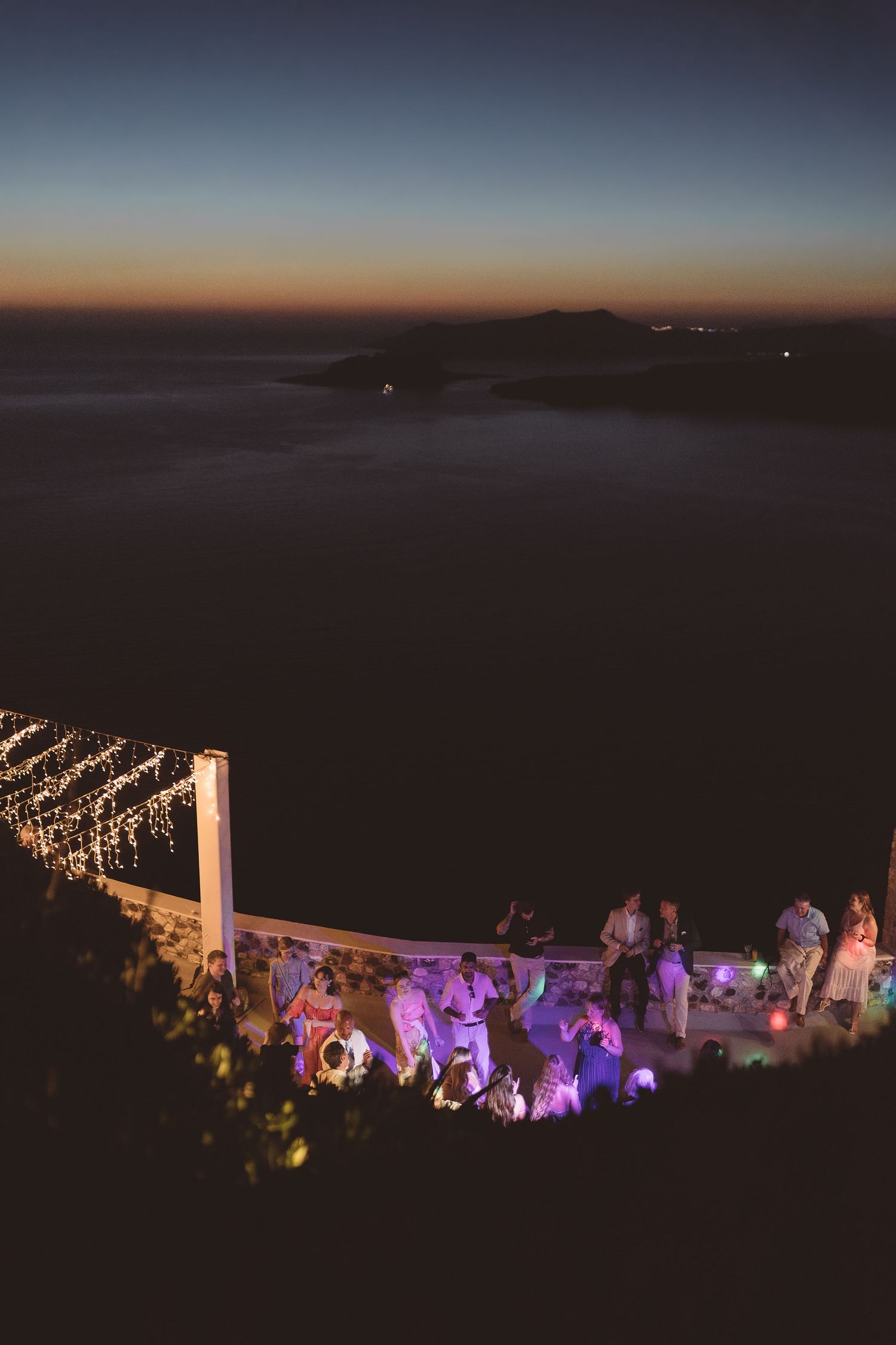 Arial view of an outdoor Santorini evening wedding reception at El Viento overlooking megalachori caldera.