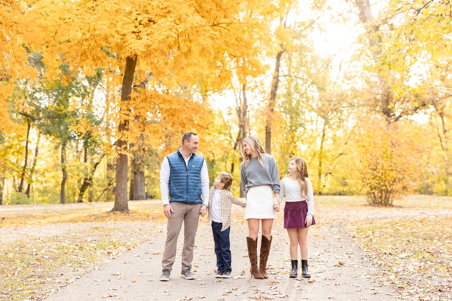 Clear Lake Family photo session with walking together on a path covered in golden autumn leaves during a sunny fall day