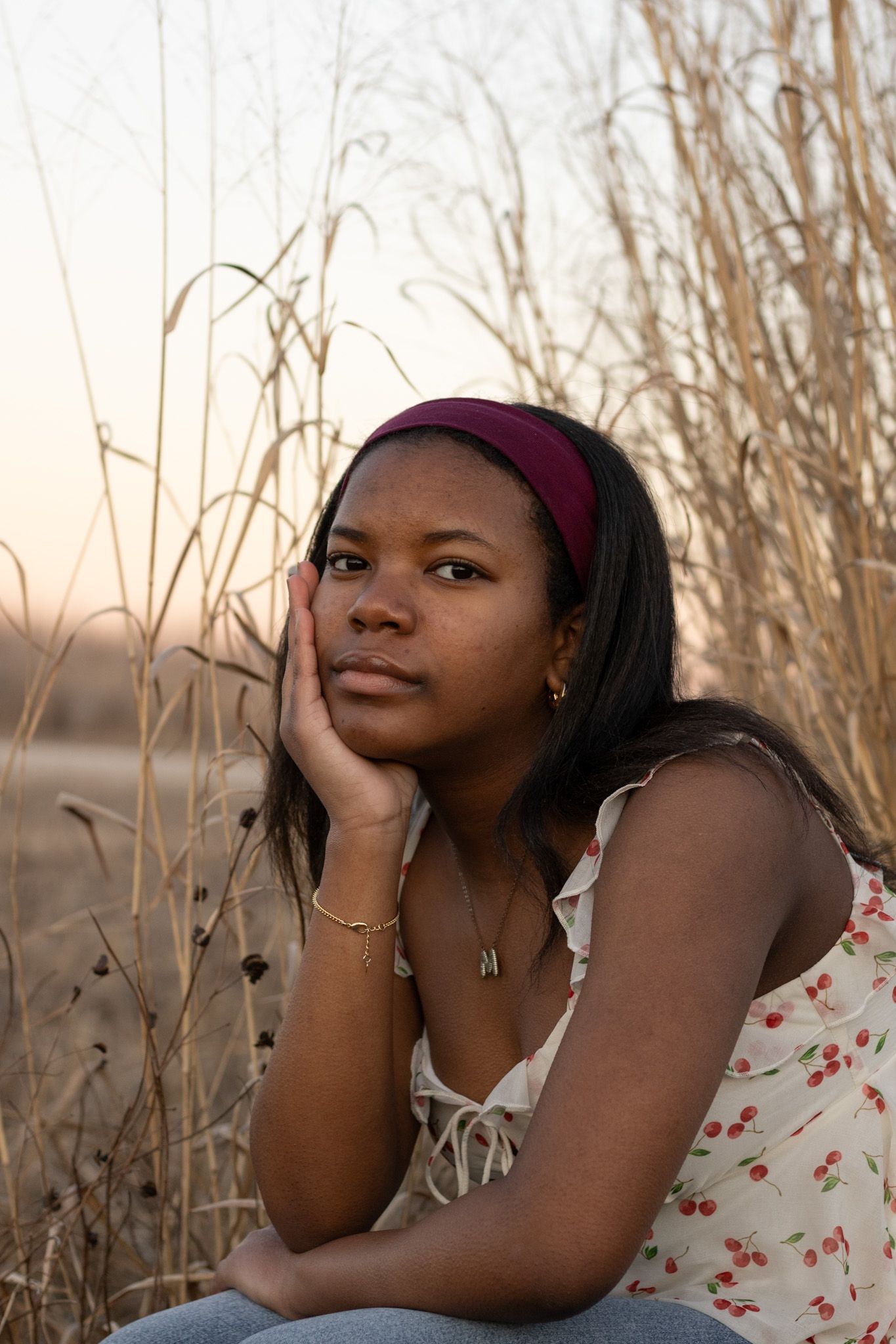 A thoughtful moment captured in warm evening light among dried grasses.