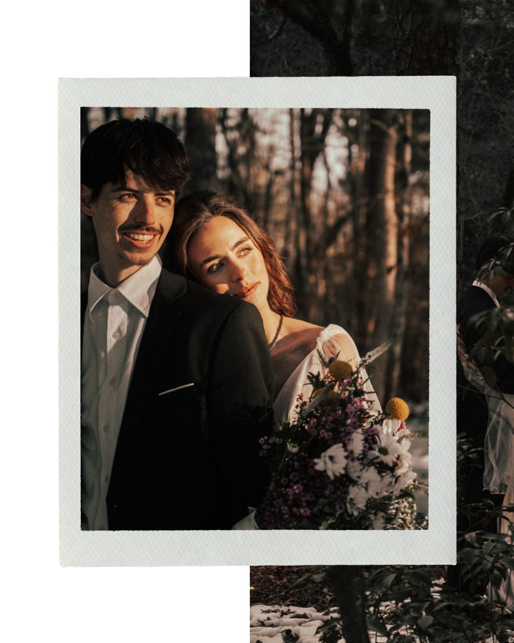 A romantic couple embraces in warm sunset lighting with purple floral arrangements in a wooded outdoor setting.