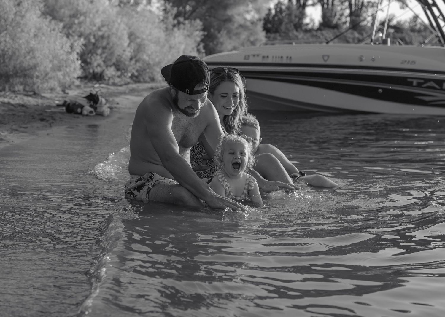 Series of black and white photos showing family splashing in water.