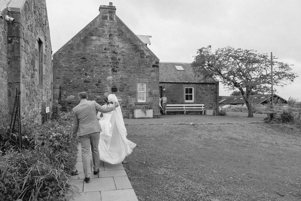 A series of black and white photos showing stone buildings and garden paths in a historic setting.