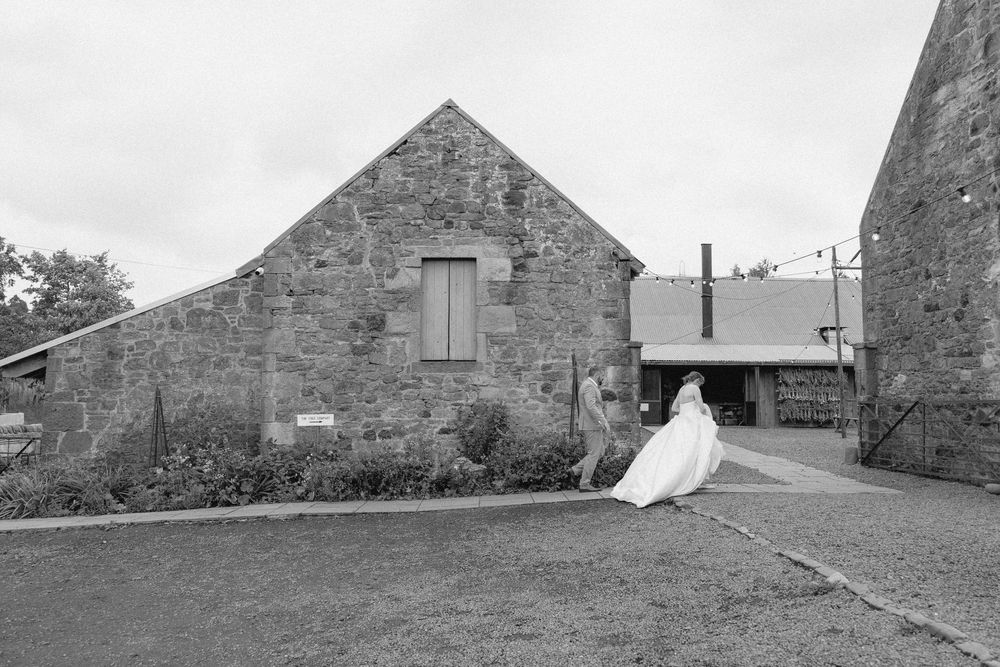 A series of black and white photographs showing historic stone buildings and rural landscapes in a pastoral setting.