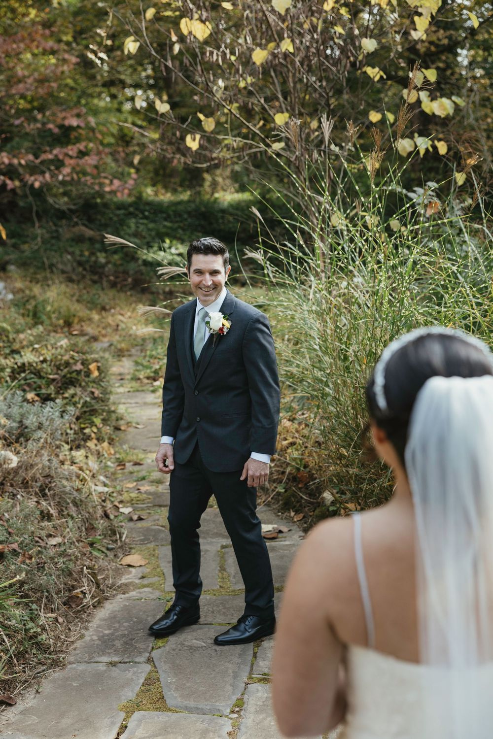 A wedding first look sequence showing anticipation and reactions in an outdoor garden setting with autumn foliage.