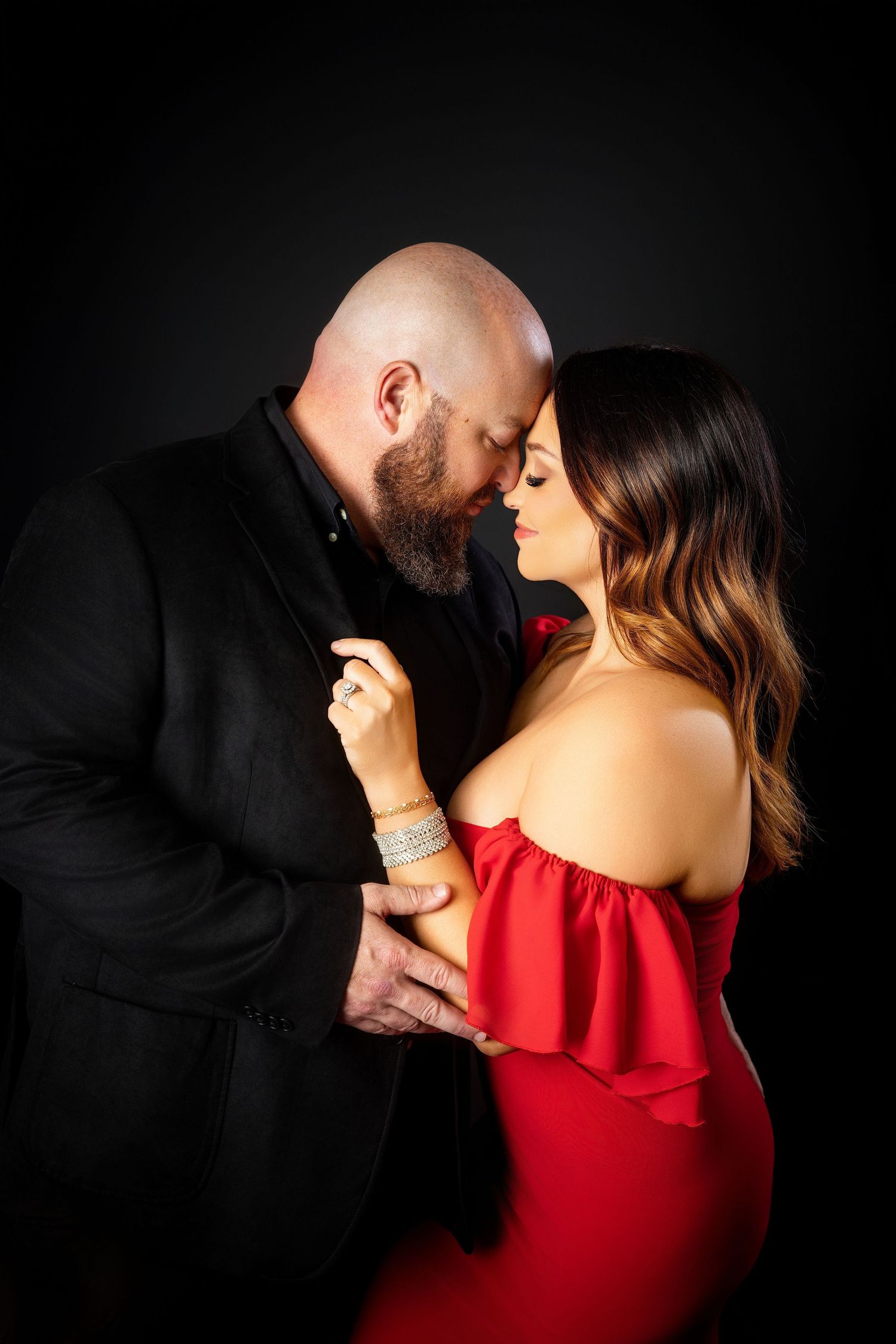 Stylish couple poses together in formal attire with woman in black dress and man in dark suit.  Knoxville couple photography session