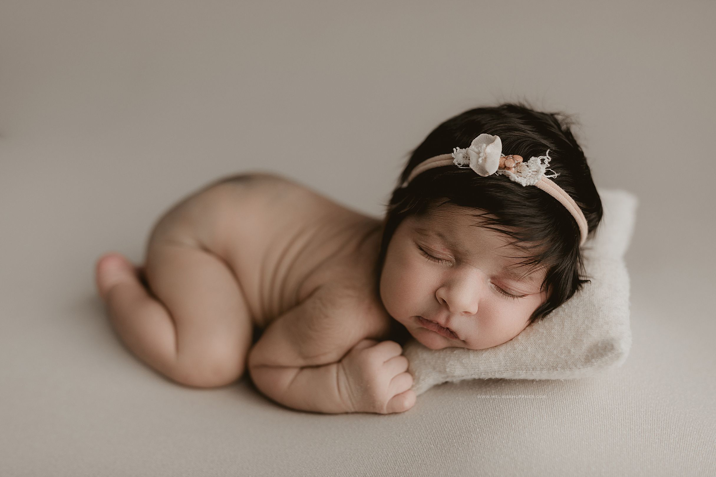 A collection of artistic newborn baby photography poses on a neutral beige background.