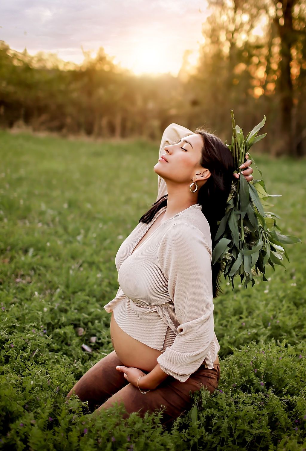 Pregnant mama in beautiful field taking pictures for her maternity session