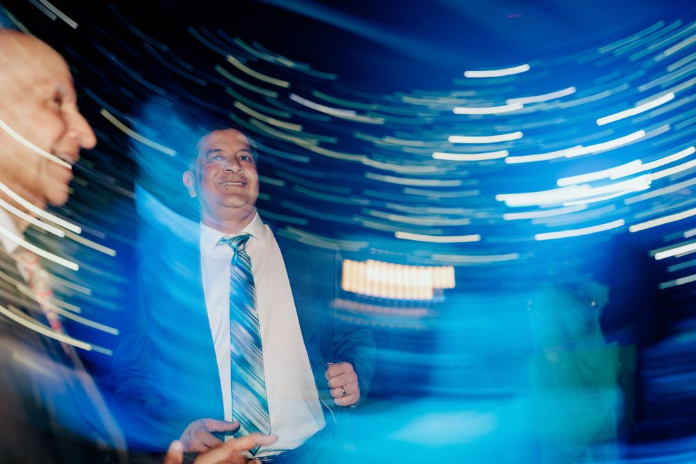 Dance party scene with streaking blue lights and motion blur effects creating dynamic nightclub atmosphere.