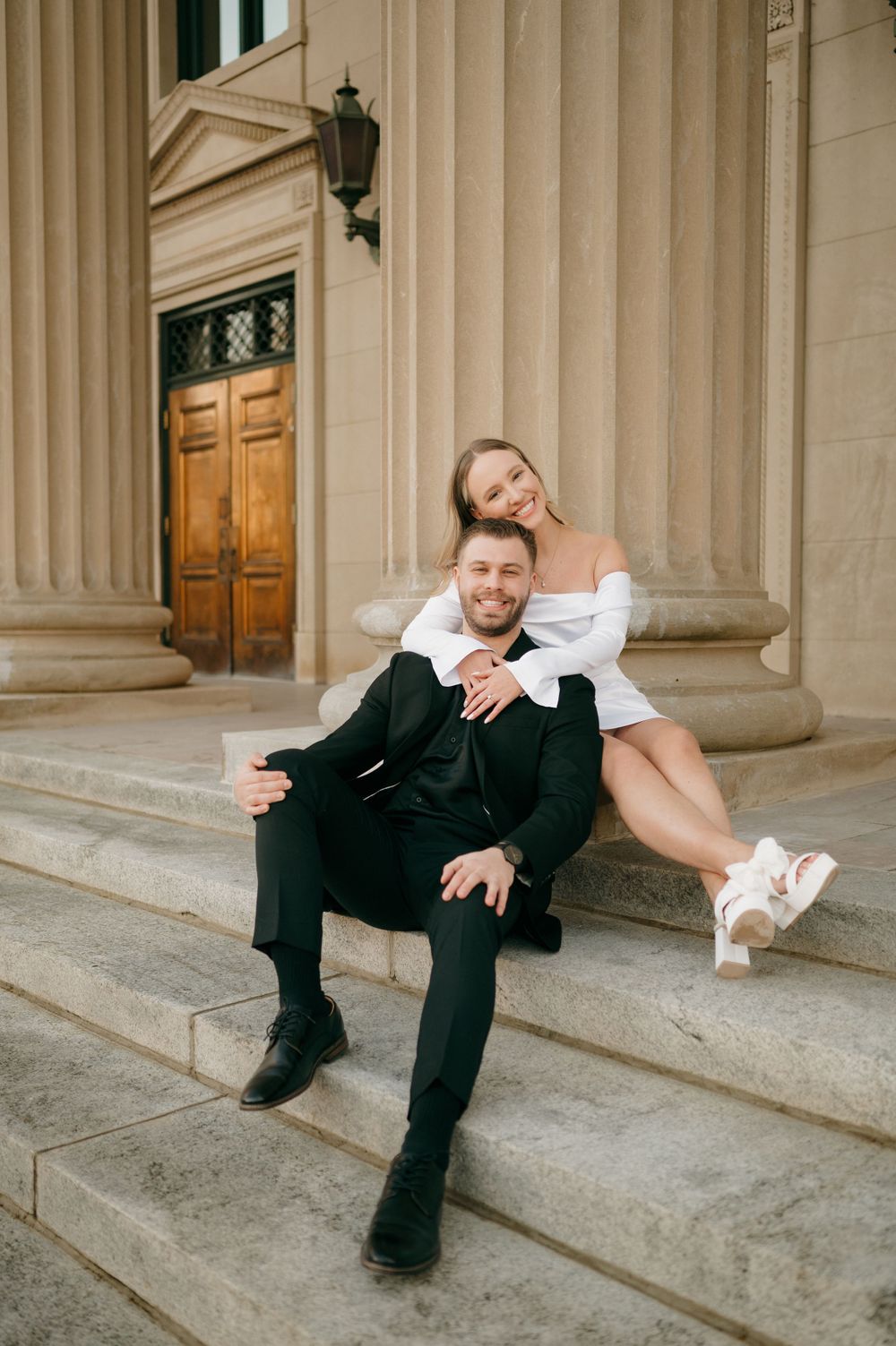 A romantic photo session on classic stone steps with elegant columns in the background.