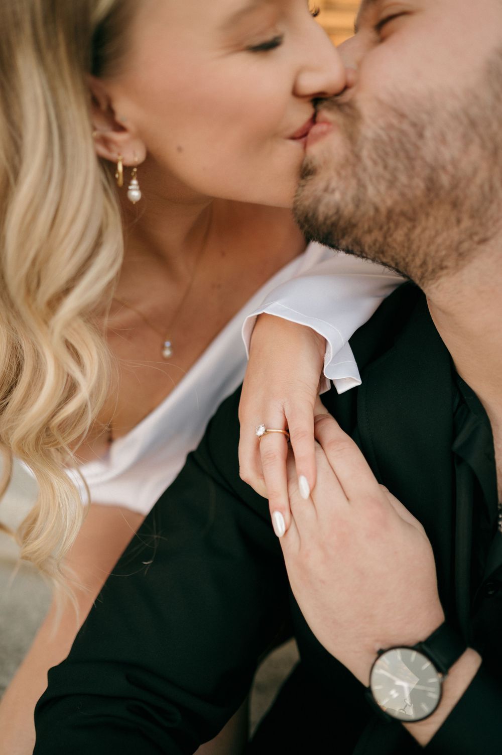 Close-up shot of a romantic kiss showing engagement ring and elegant jewelry details. Charlotte Wedding Photographer