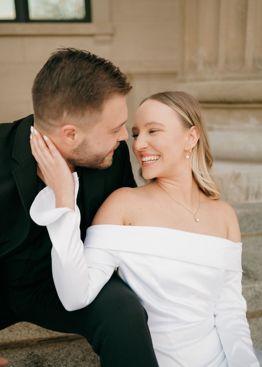 An intimate moment shared between a couple dressed in black and white during their engagement session in uptown Charlotte.