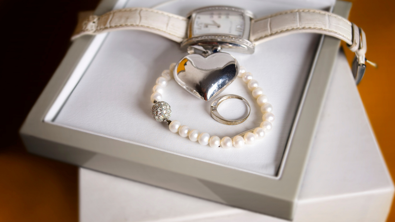 Jewellery box with white leather watch, bead necklace and ring