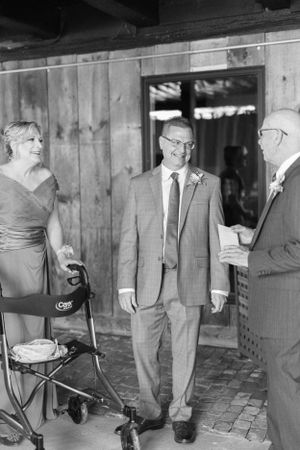Vintage black and white photo of men in suits gathered in a rustic indoor setting.