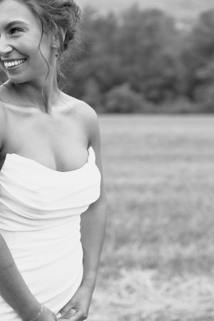 Black and white photo series showing candid joyful moments in an outdoor field setting with a white off-shoulder top.