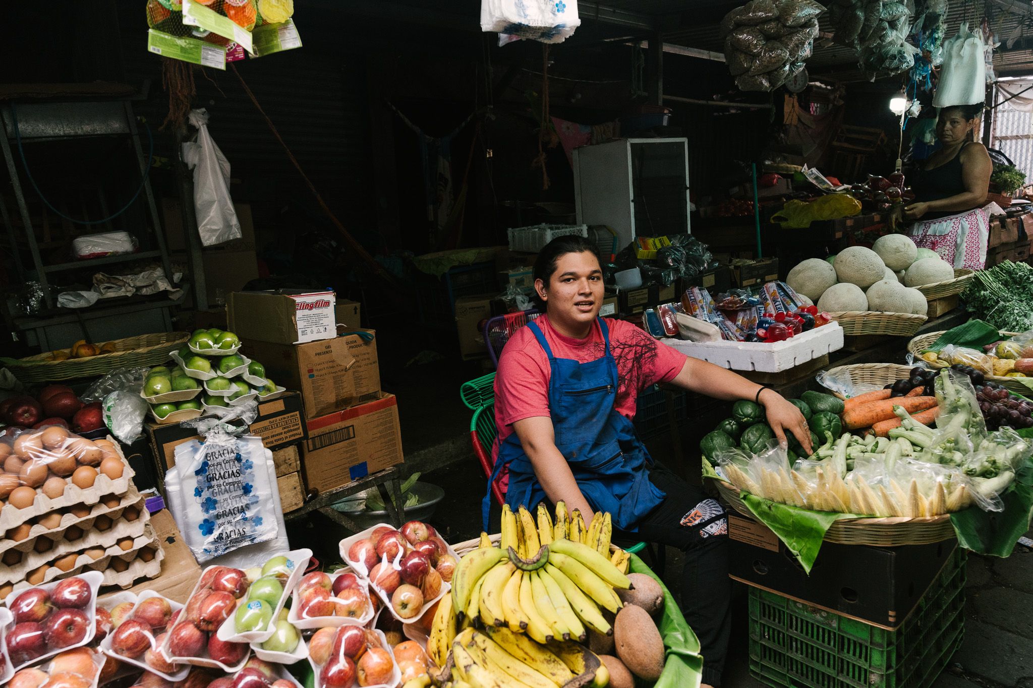 Fresh produce vendor selling fruits and vegetables at an outdoor market.