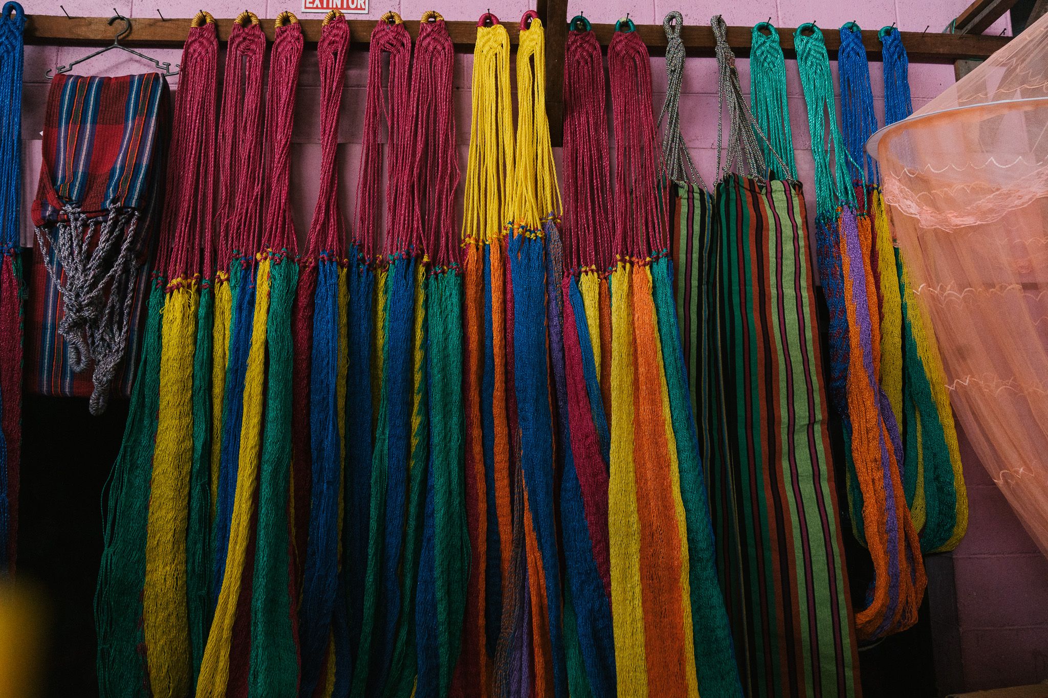 Colorful textiles and fabrics hanging on display at market.