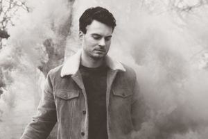 Atmospheric black and white portrait with smoke effects in dramatic lighting.