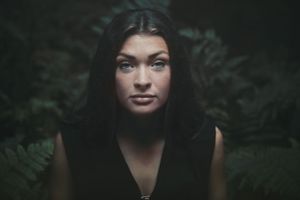Dramatic dark portrait with moody lighting and shadows.