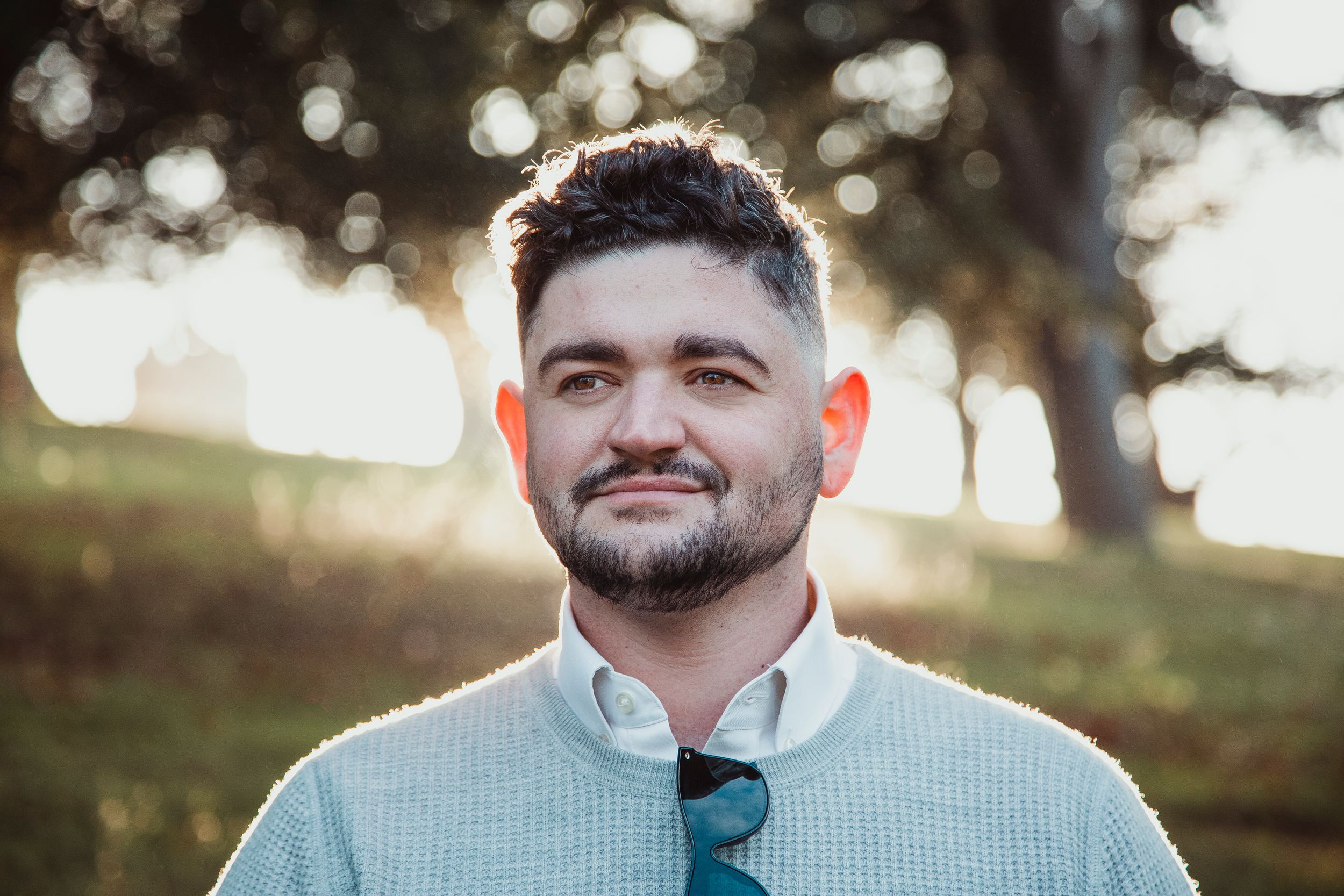 Casual outdoor portrait against blurred natural background.