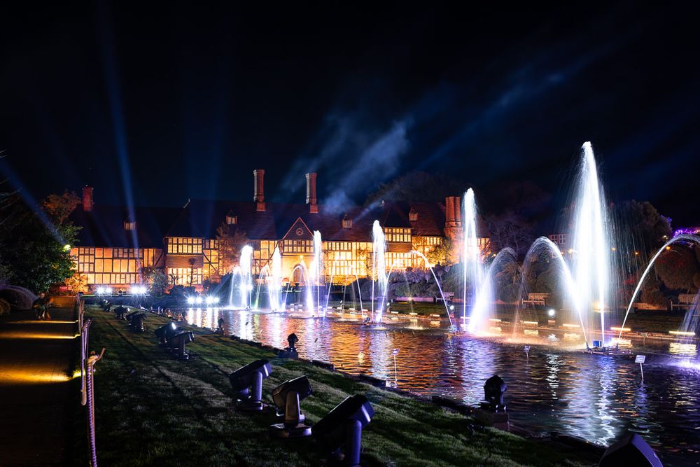 Illuminated fountains and water features create a stunning nighttime display for Glow at RHS Wisley, Surrey.