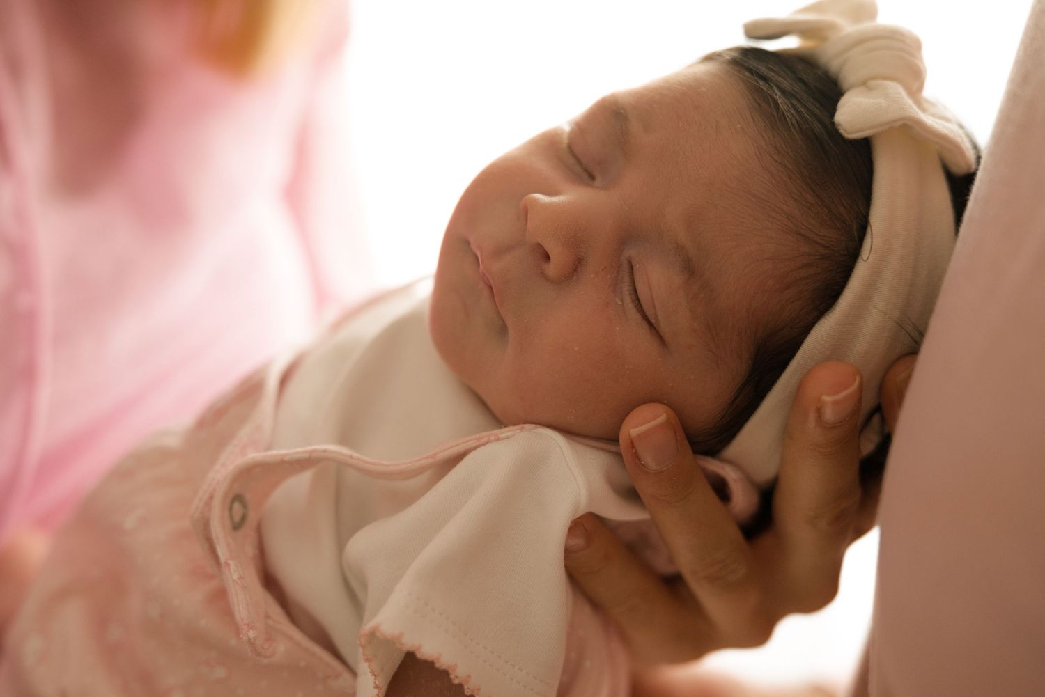 photo d'un bébé qui dort dans les bras de sa maman