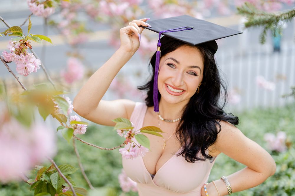 Graduation portrait surrounded by delicate pink spring cherry blossoms.