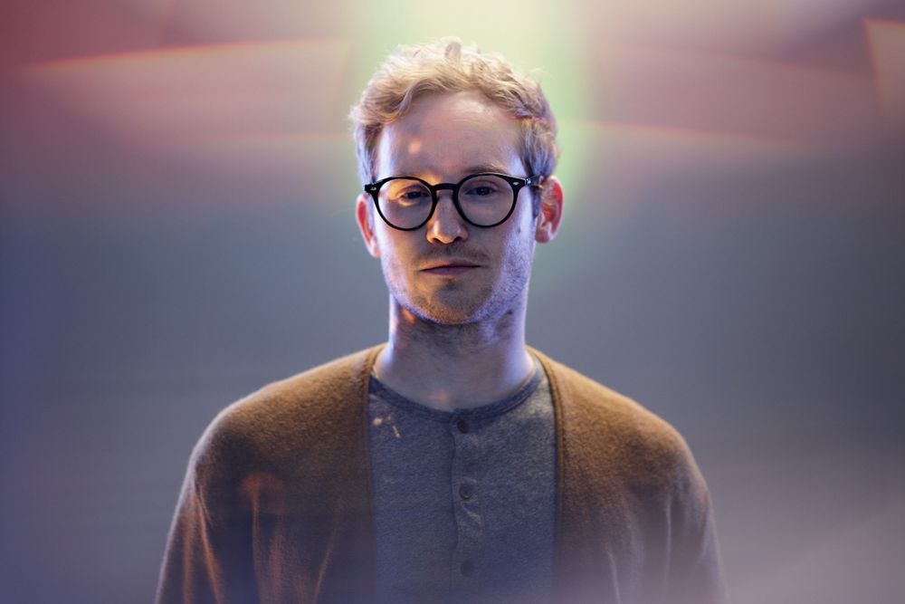 Moody portrait with atmospheric lighting and glasses.
